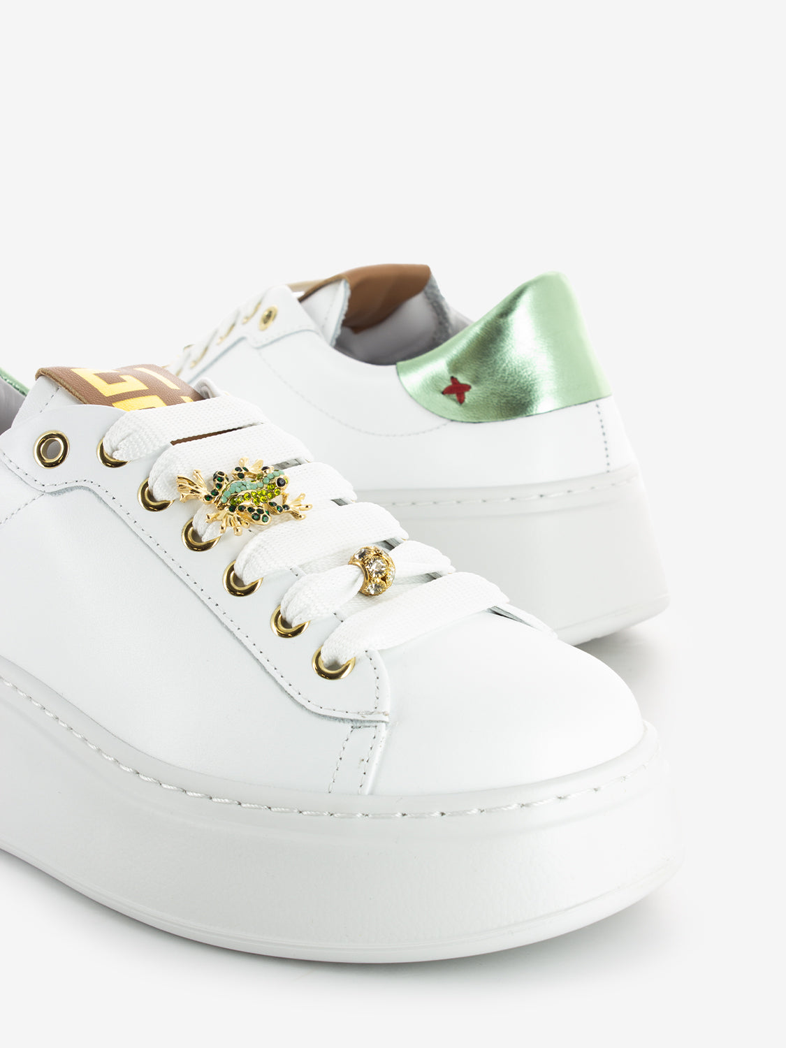Sneakers with white / green frog brooch